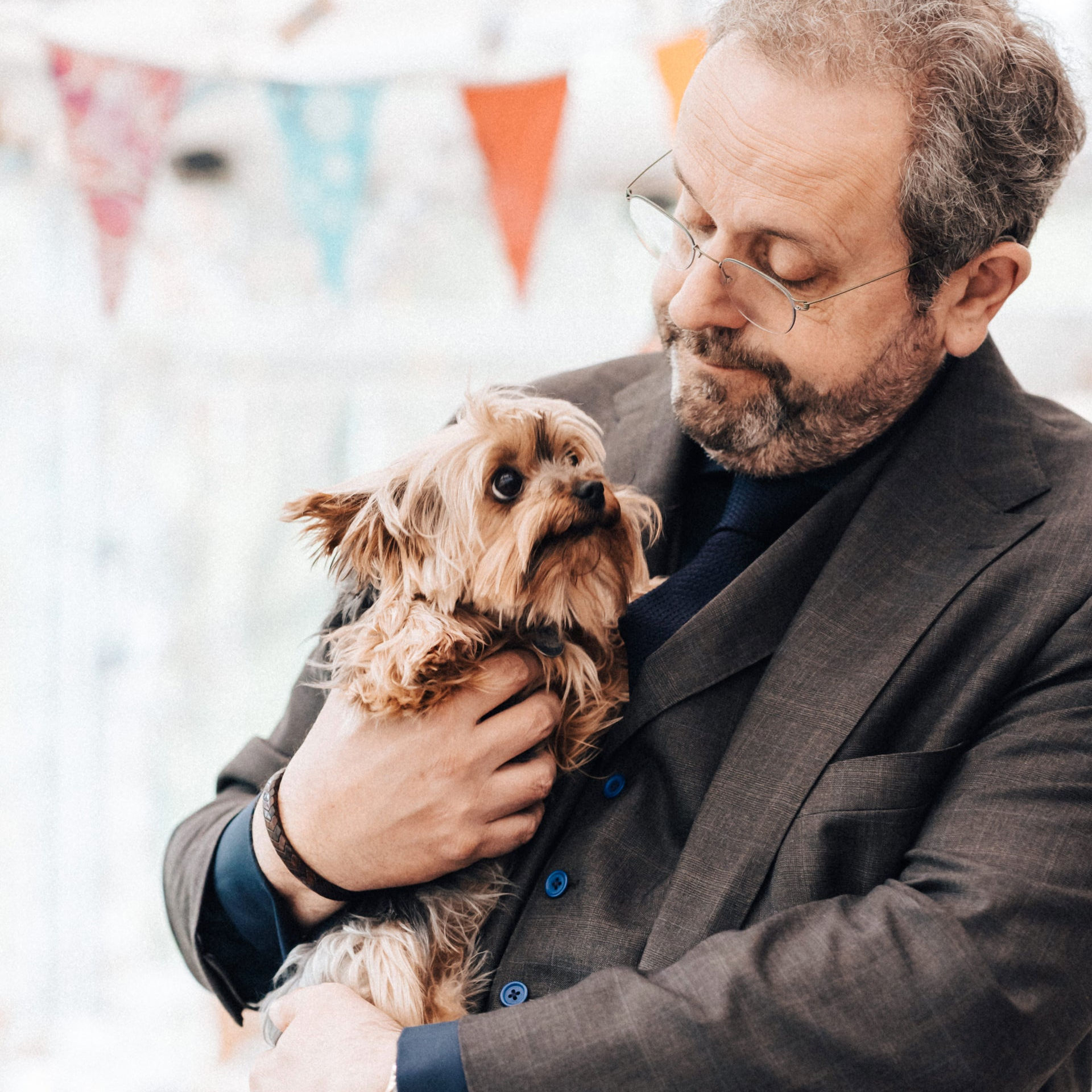 A photograph of Drew Montague holding his dog, a Yorkshire Terrier named Fizzy